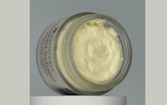 Jar of cream with visible brand name on a gray background