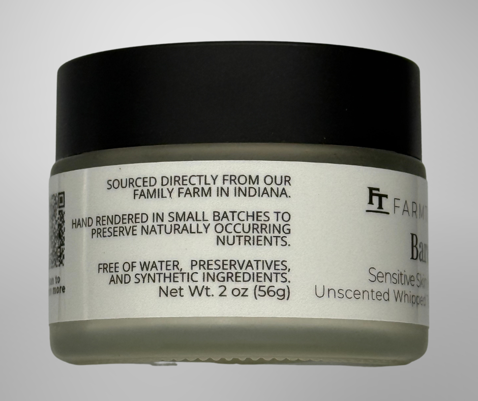 Jar of unscented whipped butter with black lid and white label on a gray background