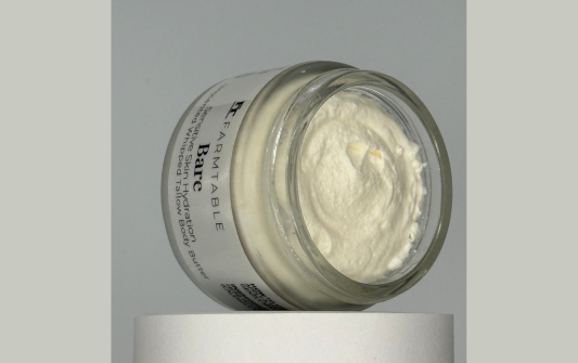Jar of cream with a white lid on a gray background
