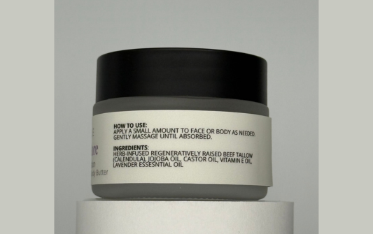 Skincare jar with black lid and gray label on a light gray background