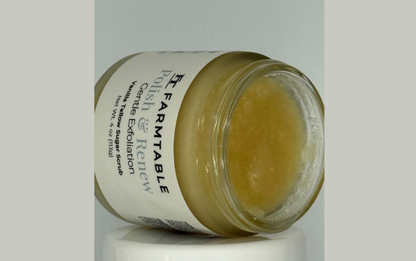 Jar of body scrub with visible brand name on a light gray background
