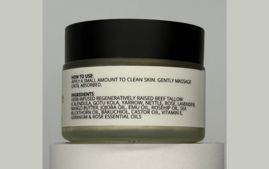 Cosmetic jar with black lid and white label on a gray background