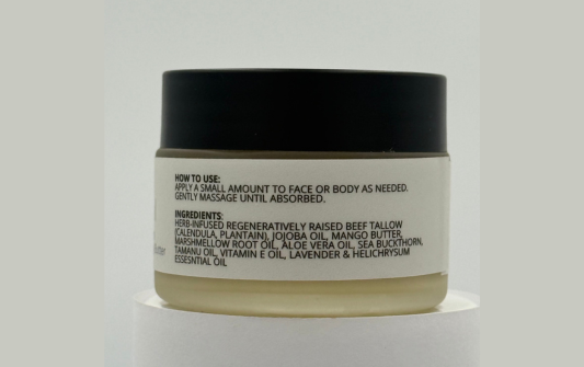 Cosmetic jar with black lid and white label on a light gray background