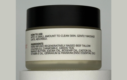 Jar of skincare product with label on a light gray background