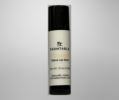 Farmtable Orange Tallow Lip Balm on a gray background