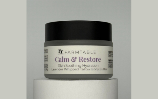 Jar of Farmtable Calm & Restore body butter on a gray background