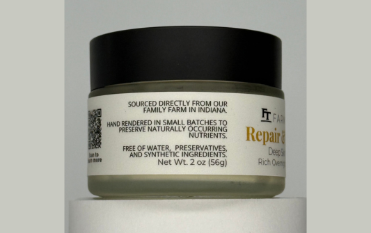 Jar of repair cream with a black lid on a gray background