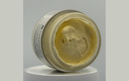 Open jar of cream on a gray background