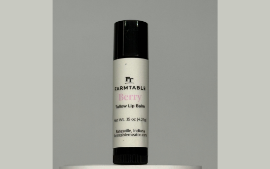 Lip balm container with 'Farmtable' branding on a gray background