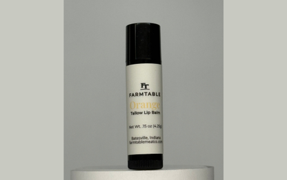 Lip balm with 'Farmtable' branding on a gray background