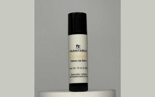 Lip balm with 'Farmtable' branding on a gray background
