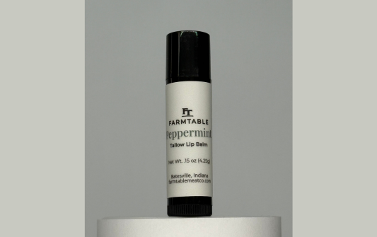 Lip balm with 'Farmtable' branding on a gray background