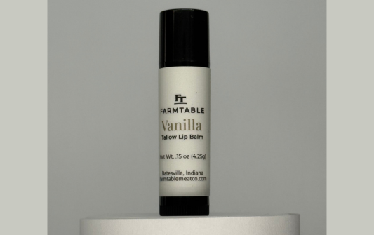Vanilla lip balm with 'Farmland' branding on a gray background