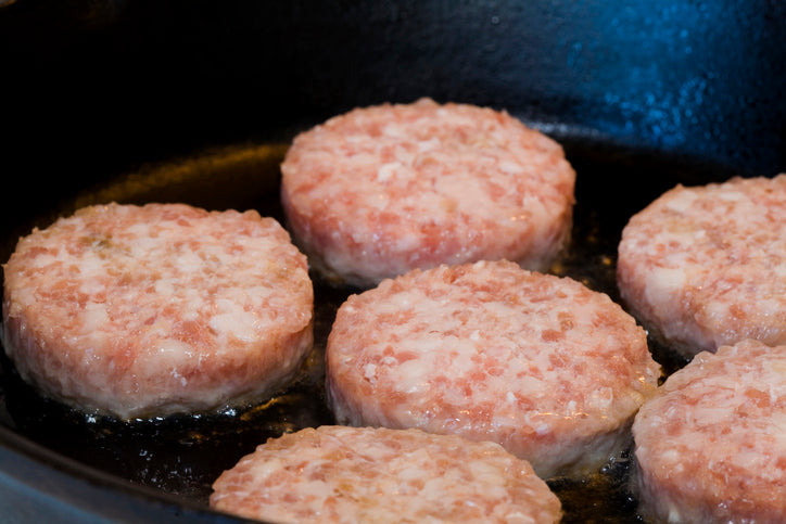 Sausage patties cooking in a frying pan