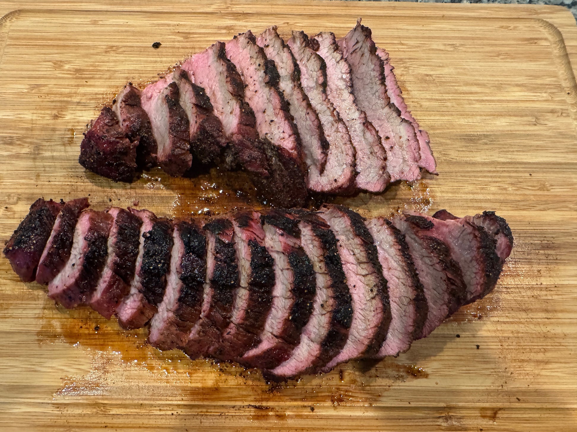 Sliced tri tip on a wooden cutting board